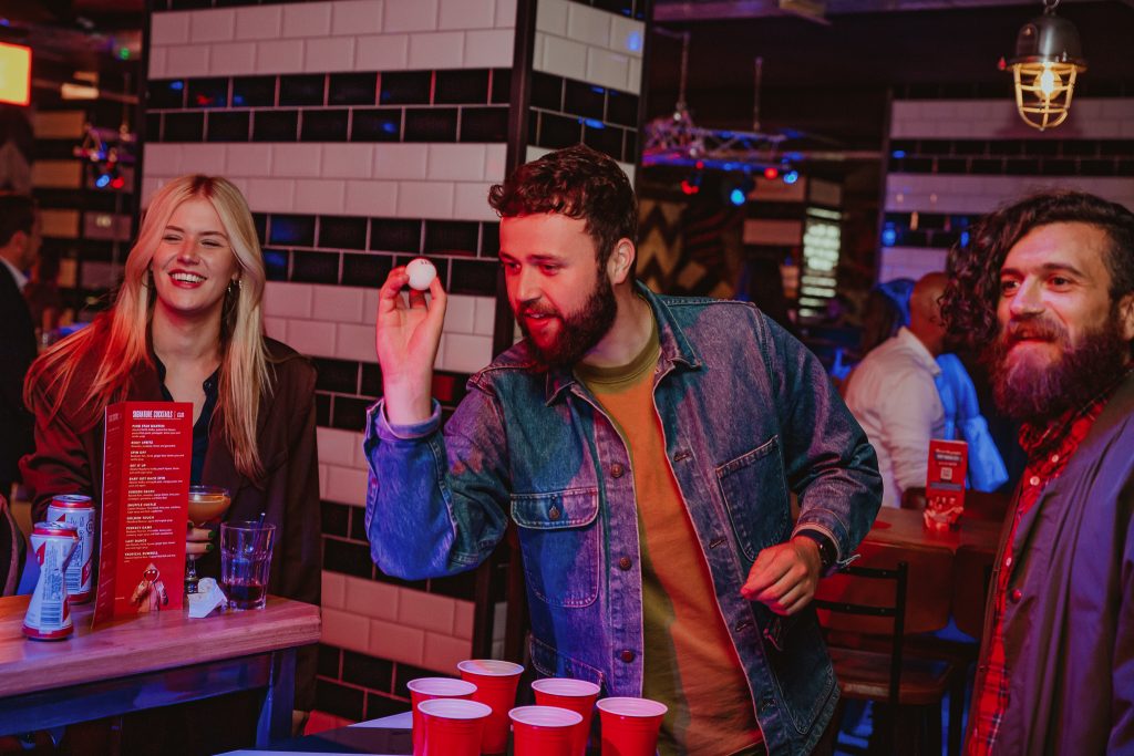 A group of people playing beer pong at Roxy Ballroom