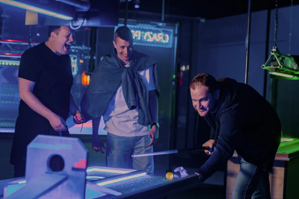Three men playing crazy pool at Roxy Lanes
