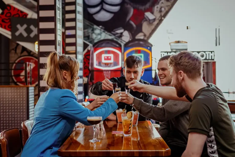 A group of friends cheers their drink sat Roxy